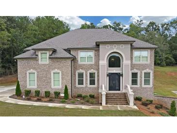 Brick two-story home with landscaped yard and large driveway at 3317 Steeple Chase Way, Conyers, GA 30094