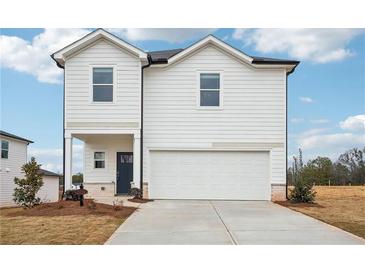 Two-story home with white siding, a two-car garage, and a well-manicured front lawn at 2024 Avalon Rdg, Conyers, GA 30013