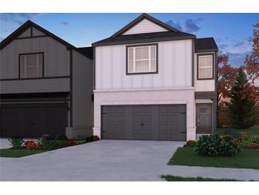Charming two-story home with a brick and white facade, a dark grey garage door, and well-maintained landscaping at 2121 Avalon Rdg, Conyers, GA 30013