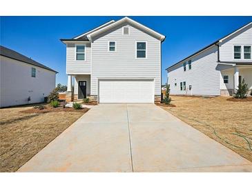 Two story home featuring a two car garage, light gray siding and a concrete driveway at 2032 Avalon Rdg, Conyers, GA 30013