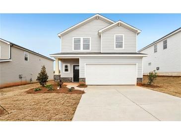 Charming two-story home with light gray siding, a two-car garage, and a neatly landscaped front yard at 2036 Avalon Rdg, Conyers, GA 30013
