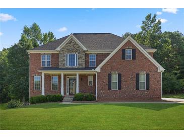 Brick two-story house with stone accents, a large front yard, and a covered porch at 3247 Brigadier Way, Stockbridge, GA 30281