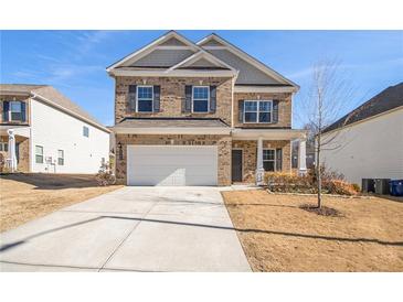 Two-story brick home with a white garage door and landscaping at 6094 Whitetail Deer Run, Mableton, GA 30126
