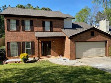 Brick two-story house with a two-car garage and landscaping at 5958 King Way Walk, Lithonia, GA 30058