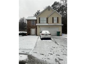 Two-story house with stone and vinyl siding, snow covered lawn, attached garage at 6603 Biscayne Blvd, Rex, GA 30273