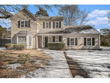 Two-story house with light beige siding, a covered porch, and a snow-covered driveway at 3712 Windy Hill Se Dr, Conyers, GA 30013