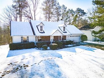 Snow-covered house with stone accents and landscaping at 95 Brandon Dr, Covington, GA 30016