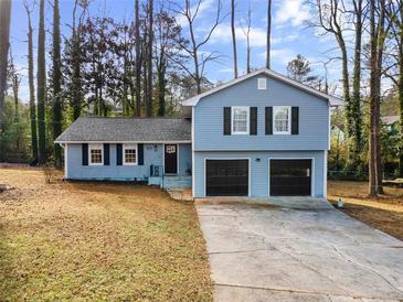 Newly renovated light blue home with a two-car garage and manicured lawn at 4611 Eberline Ct, Stone Mountain, GA 30083