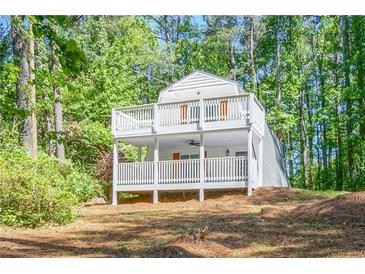 A-frame home with white siding, deck, and wooded lot at 3918 Hardee Nw Dr, Kennesaw, GA 30152