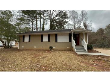 Tan brick ranch house with a covered entry and small front yard at 3770 Larkspur Ter, Decatur, GA 30032