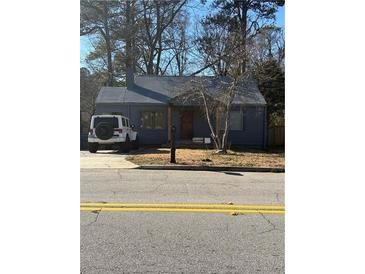 Cute bungalow with a gray exterior, nicely landscaped yard, and a driveway at 1876 Connally Dr, East Point, GA 30344