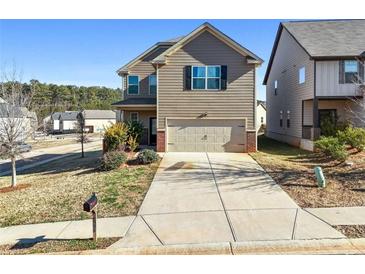Two-story house with brown siding, attached garage, and landscaped lawn at 2528 Shropshire Pl, Mcdonough, GA 30253