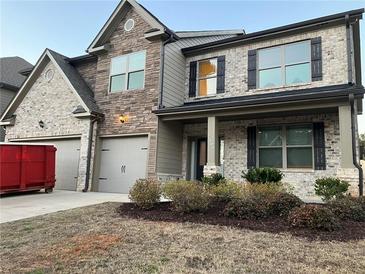 Two-story brick home with a three-car garage and landscaping at 7594 Shady Maple Way, Lithonia, GA 30038