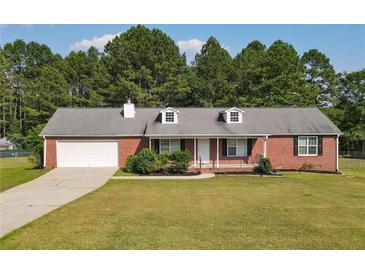 Brick ranch house with attached garage and spacious yard at 1308 Crumbley Rd, Mcdonough, GA 30252