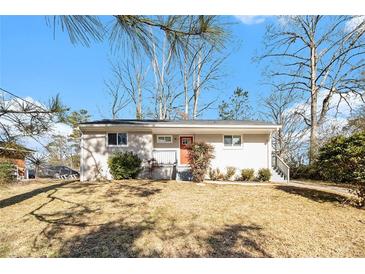 Newly renovated Ranch home with a red door and landscaped lawn at 2352 Scotty Cir, Decatur, GA 30032
