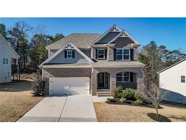 Two-story house with gray siding, brick accents, and a three-car garage at 505 Blue Mountain Rise, Canton, GA 30114