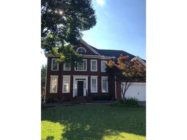 Brick two-story house with a landscaped lawn at 205 Glenbrook Ln, Canton, GA 30115