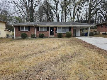 Brick ranch house with carport and a yard at 3445 Mell Pl, Clarkston, GA 30021