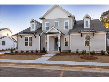 Two-story home with gray siding, a brick walkway, and landscaping at 517 Pearl St, Cumming, GA 30040