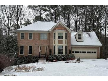 Two-story brick home with a snow covered front yard at 947 Pinbrook Dr, Lawrenceville, GA 30043