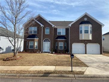 Brick two-story house with a two-car garage and landscaped yard at 1238 Polk Xing, Mcdonough, GA 30252