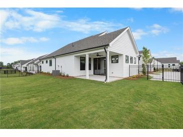 View of the home's backyard, showcasing the green lawn and outdoor patio at 515 Pearl St, Cumming, GA 30040