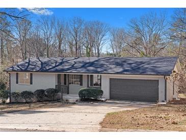 Newly renovated ranch home with gray garage door and landscaped yard at 2233 Troutdale Dr, Decatur, GA 30032