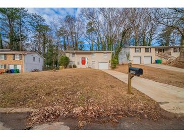 Ranch style home with red door, attached garage, and a large yard at 4424 Malibu Dr, Decatur, GA 30035