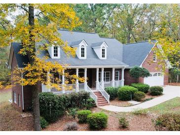 Charming brick home with a welcoming front porch, landscaped yard and beautiful autumn foliage at 1630 Bettis Tribble Gap Rd, Cumming, GA 30040