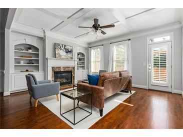 Bright living room featuring a fireplace, built-in shelving, coffered ceiling, and hardwood floors at 570 Parkside Village Nw Way # 12, Marietta, GA 30060