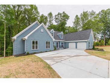 Two-story house with gray siding, three-car garage, and large driveway at 9635 Haverhill Ln, Johns Creek, GA 30022