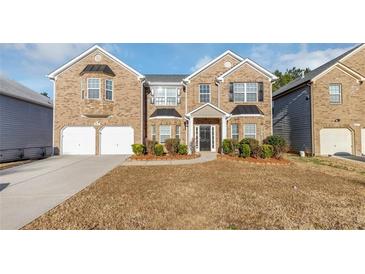 Brick two-story house with a two-car garage and landscaped front yard at 5585 Dendy Trce, Fairburn, GA 30213