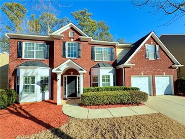 Brick two-story house with two-car garage, landscaping, and a manicured lawn at 3065 Moser Way, Marietta, GA 30060