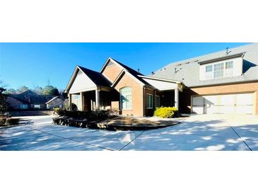 Charming brick home featuring an attached two-car garage and neatly kept landscaping in a residential area at 4140 Lanier Ridge Walk # 104, Cumming, GA 30041