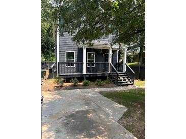 Two-story gray house with a front porch, steps, and driveway at 935 Pelham Nw St, Atlanta, GA 30318