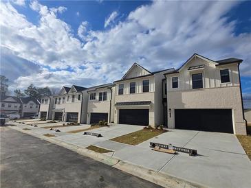 New townhouses with modern design, two-car garages, and manicured lawns at 1947 Westwind Street (Lot 163), Lawrenceville, GA 30043