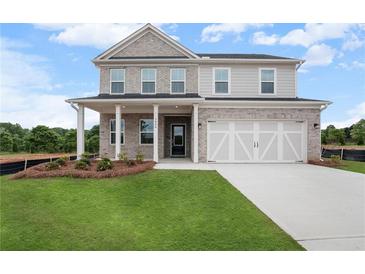 Charming two-story home with a well-manicured lawn, gray siding, and attached two-car garage at 1646 Tide Mill Rd, Cumming, GA 30040