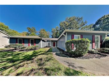 Ranch style home with gray siding, red shutters, and a well-maintained lawn at 2065 Arbor Forest Sw Dr, Marietta, GA 30064