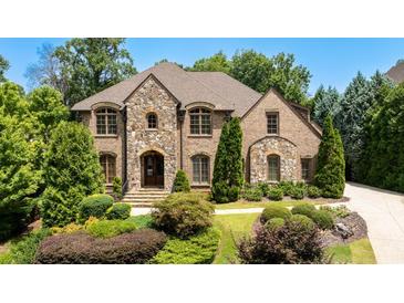Brick and stone two-story home with landscaped lawn and driveway at 830 Camden Park Ne Ct, Atlanta, GA 30342