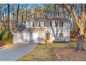 Two-story house with attached garage and landscaped yard at 620 Sheringham Ct, Roswell, GA 30076