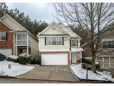 Two-story townhome with a white garage door and snow-covered landscaping at 646 Lakes Cir, Lithonia, GA 30058