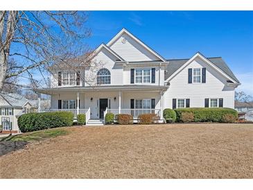 Charming two-story home featuring a welcoming front porch and well-maintained landscaping at 1515 Bullard Pl, Powder Springs, GA 30127