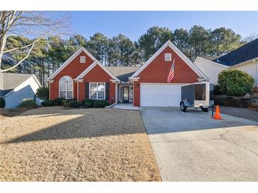 Brick ranch home with attached garage and American flag at 436 Suwanee East Dr, Lawrenceville, GA 30043