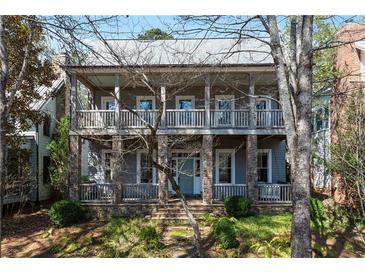 Charming two-story home with a covered front porch and stone accents at 9032 Selborne Ln, Chattahoochee Hills, GA 30268