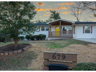 White brick ranch home with a yellow door, modern updates, and landscaped yard at 679 Montevista St, Atlanta, GA 30310