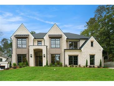 Two story house with light brick exterior, dark windows, and lush lawn at 427 Jon Scott Dr, Alpharetta, GA 30009