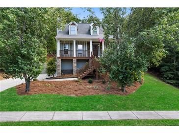 Two-story house with stone accents, wrap-around porch, and landscaped yard at 12 Spruce Ne St, White, GA 30184