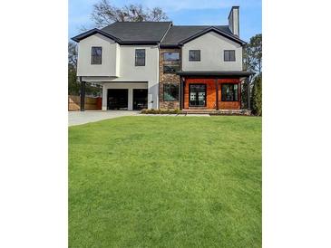 Modern two-story home featuring a well-manicured lawn and an attached two-car garage at 2571 Sharondale Ne Dr, Atlanta, GA 30305