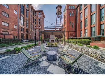 Charming outdoor common area featuring a fireplace, seating, and a water tower in a historic brick building at 170 Boulevard Se # H412, Atlanta, GA 30312