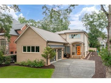 Two-story house with tan brick and gray garage doors at 4225 Maner Se St, Smyrna, GA 30080